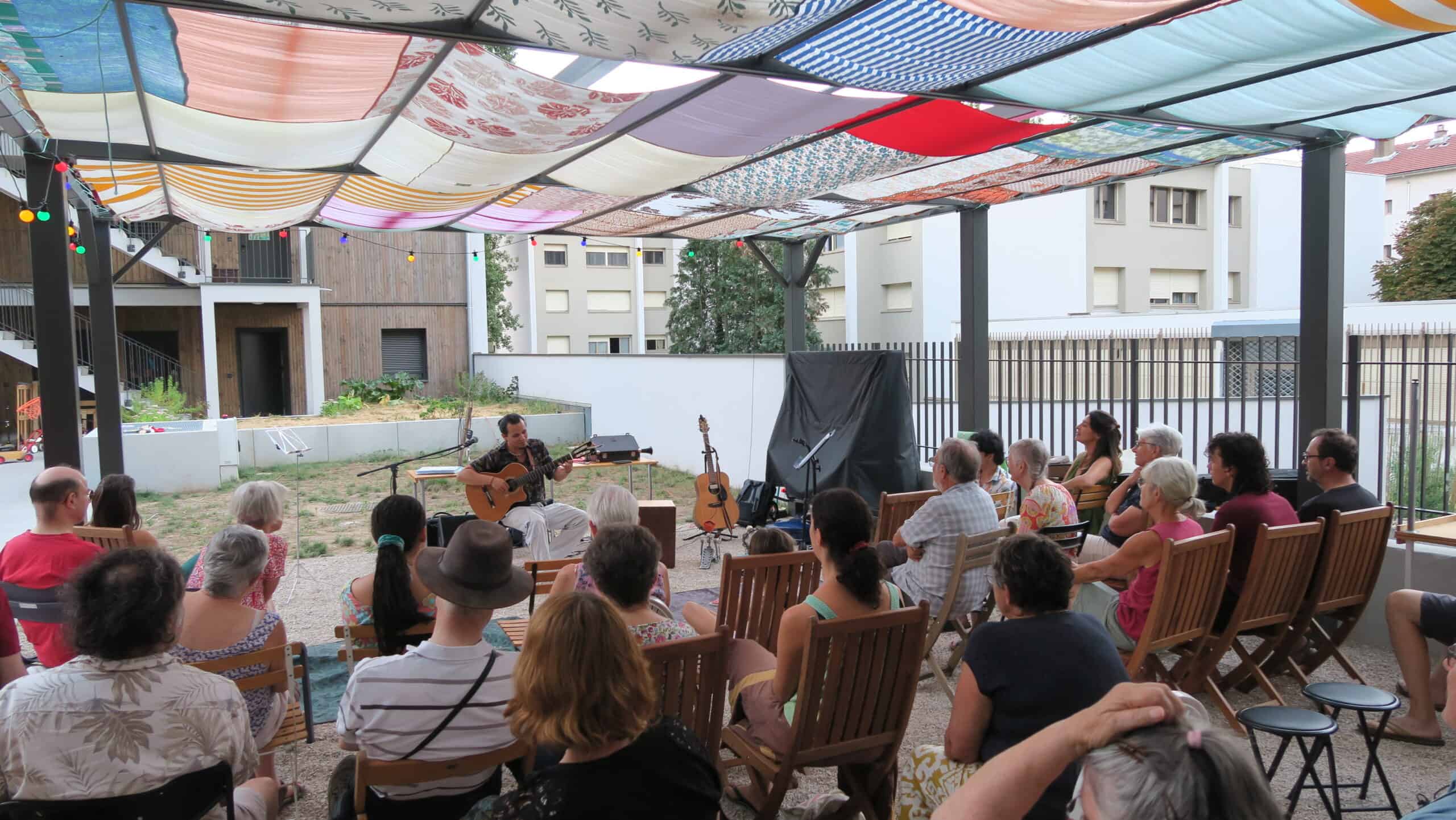 Soir&eacute;e pergola &agrave; Tr&eacute;voulution - Un chanteur avec une guitare se produit devant les habitants.